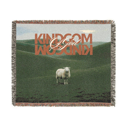 Woven blanket with a sheep in a field and 'Kingdom of God' text.
