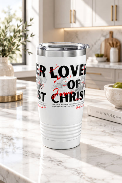 A white insulated travel tumbler with a clear lid, featuring a graphic print with the text 'LOVER OF CHRIST' in black and red script with gray illustrations, shown on a plain white background.