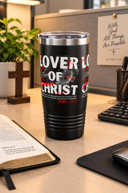 A black insulated travel tumbler with a clear lid, featuring a graphic print that reads 'LOVER OF CHRIST' in white and red with subtle smoke effects, shown on a plain white background.