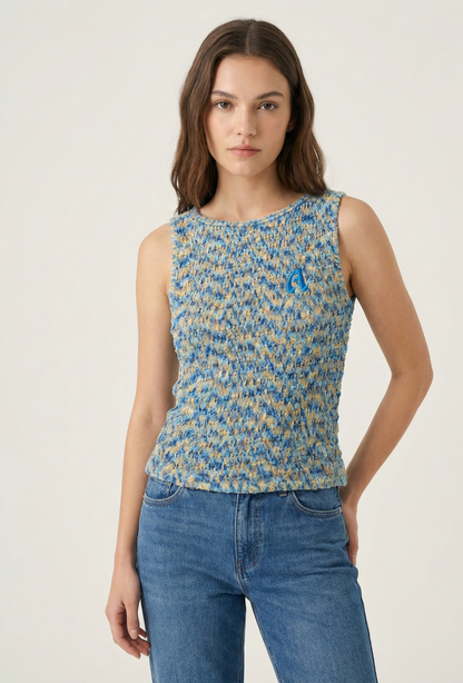 Woman wearing a blue and yellow patterned sleeveless top with a white background